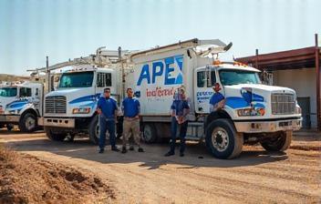 Apex Plumbing crew and work trucks at a job site